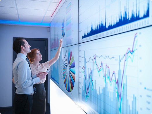 Coworkers looking at graphs on a whiteboard screen