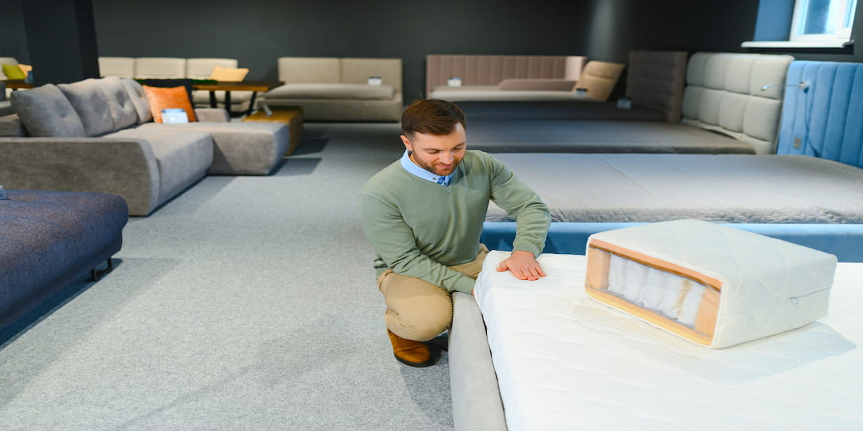 man putting bed sheets on bed