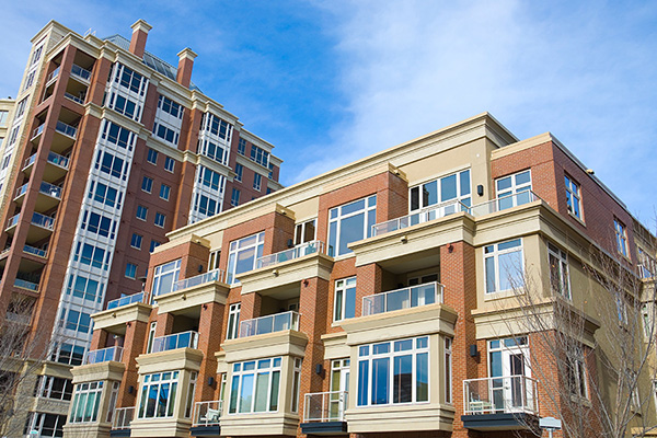 modern apartment buildings with large windows and balconies under a clear blue sky