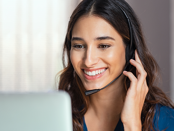 person with headset holding microphone near mouth, sitting at a computer