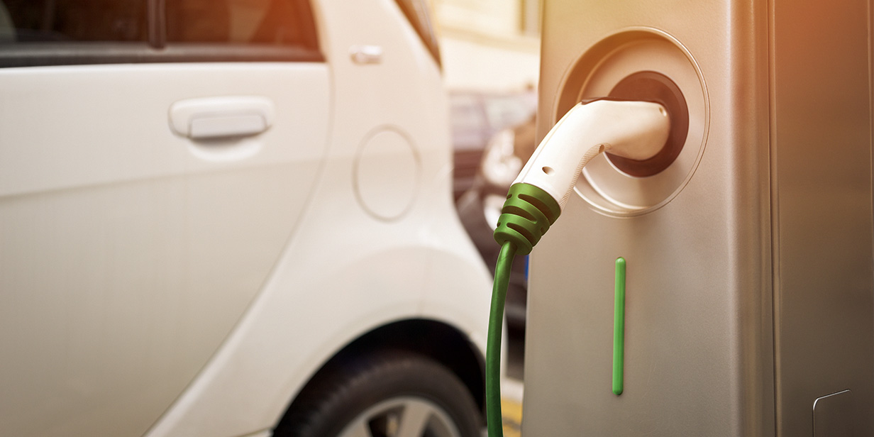 close-up of an electric car connected to a public EV charging station