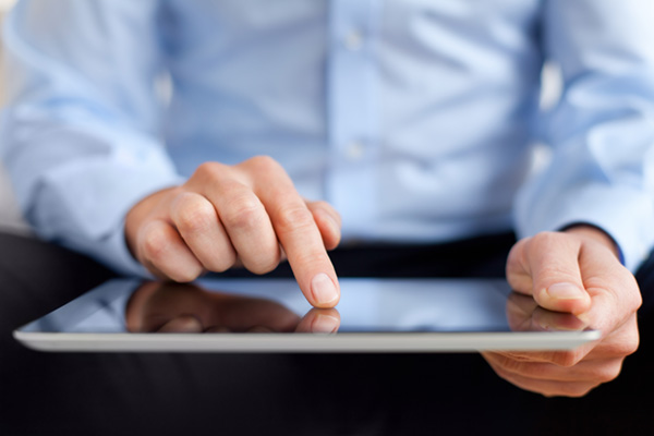 person in a light blue shirt using a tablet